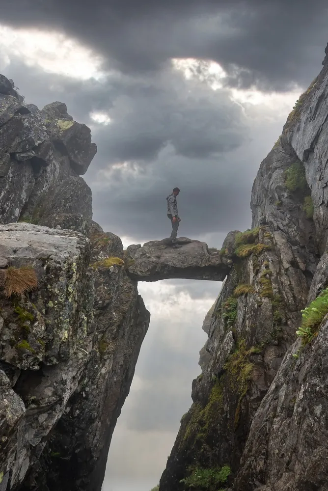 Djevelporten boulder wedged in its rocky cleft above Svolvær