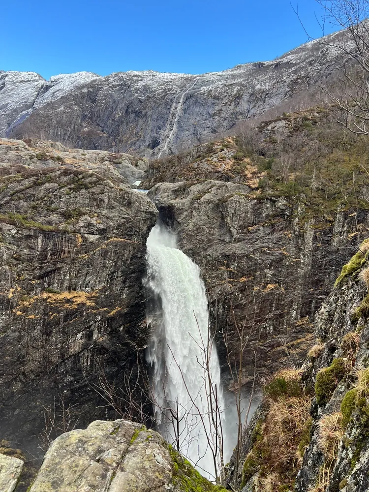 Månafossen flowing beneath a lightly snow-covered Frafjord valley